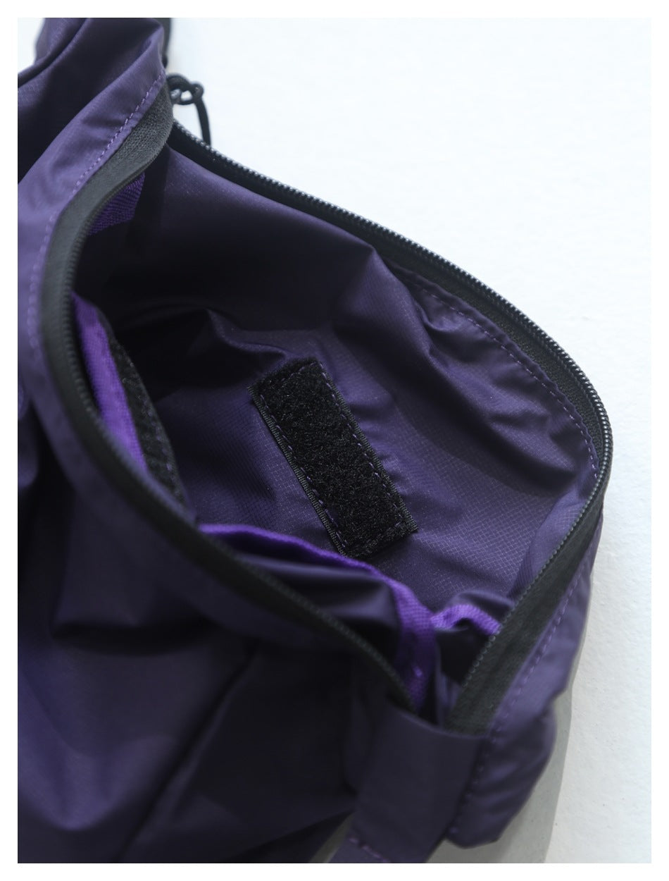 Close-up inside the purple bag showing its lining, zipper, and a black hook-and-loop fastening strip.