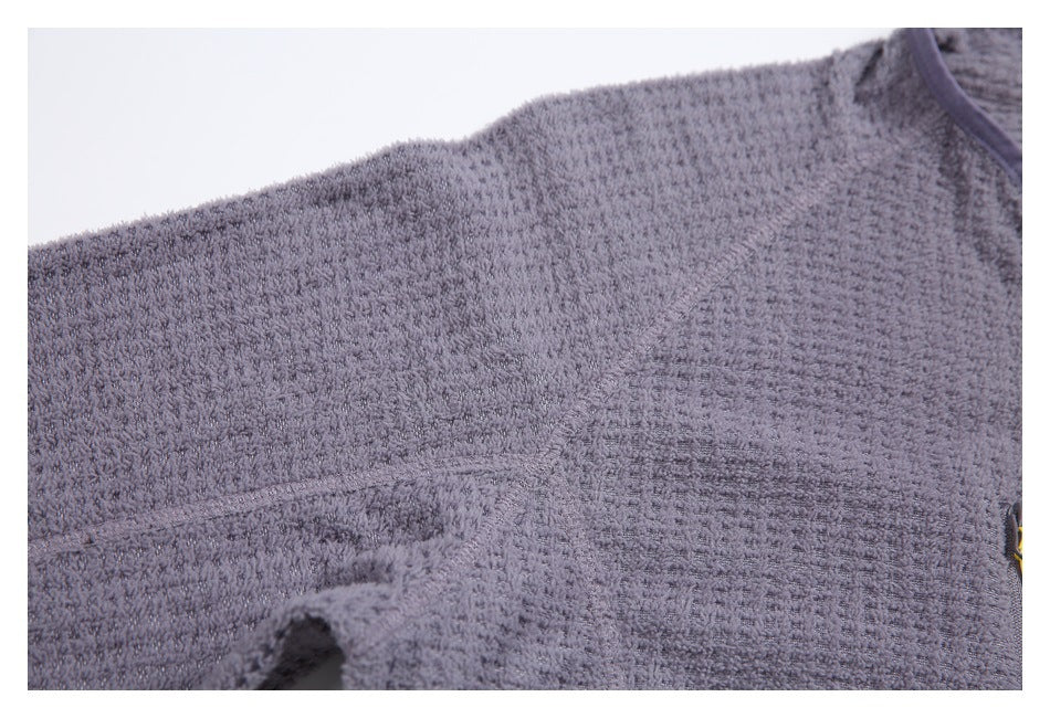 Extreme close-up of the lavender-gray jacket's textured fabric and stitched seam.