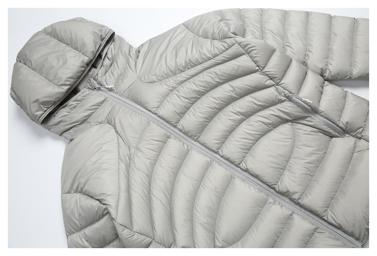 Close-up of a light-gray puffer jacket showing its diagonal zipper and quilted panels.