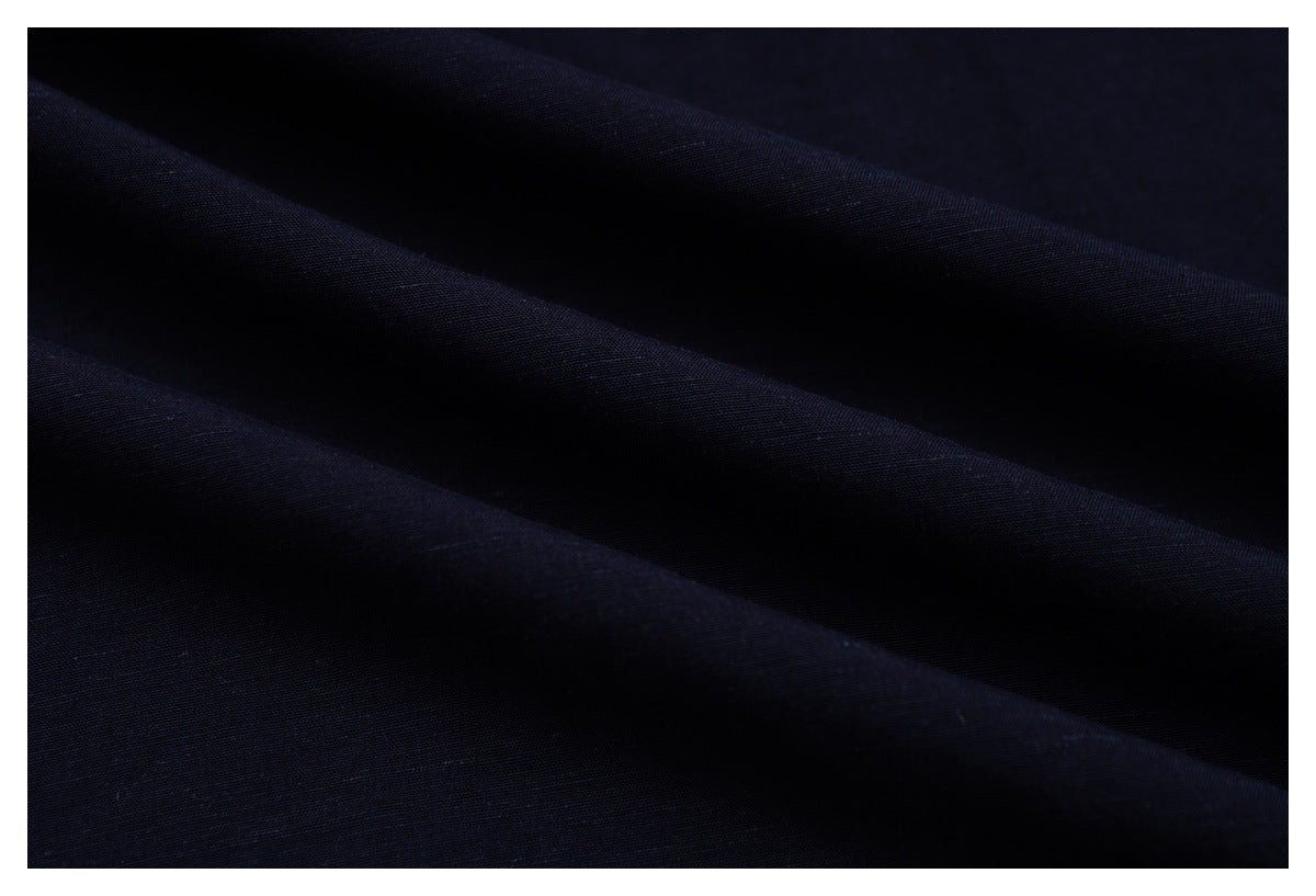 Close-up of dark navy fabric draped in soft folds, showing its surface texture.