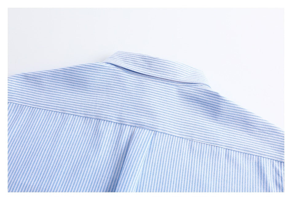 Close-up of the back yoke and collar of a white shirt with fine blue stripes.