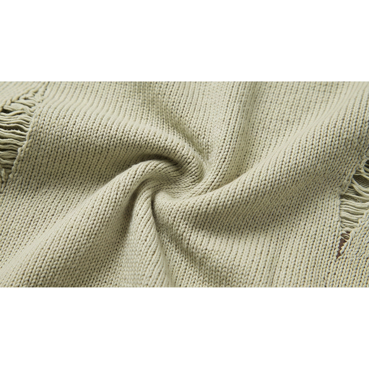 Close-up of pale beige rib-knit fabric gathered into folds, with fringe visible at the edges.