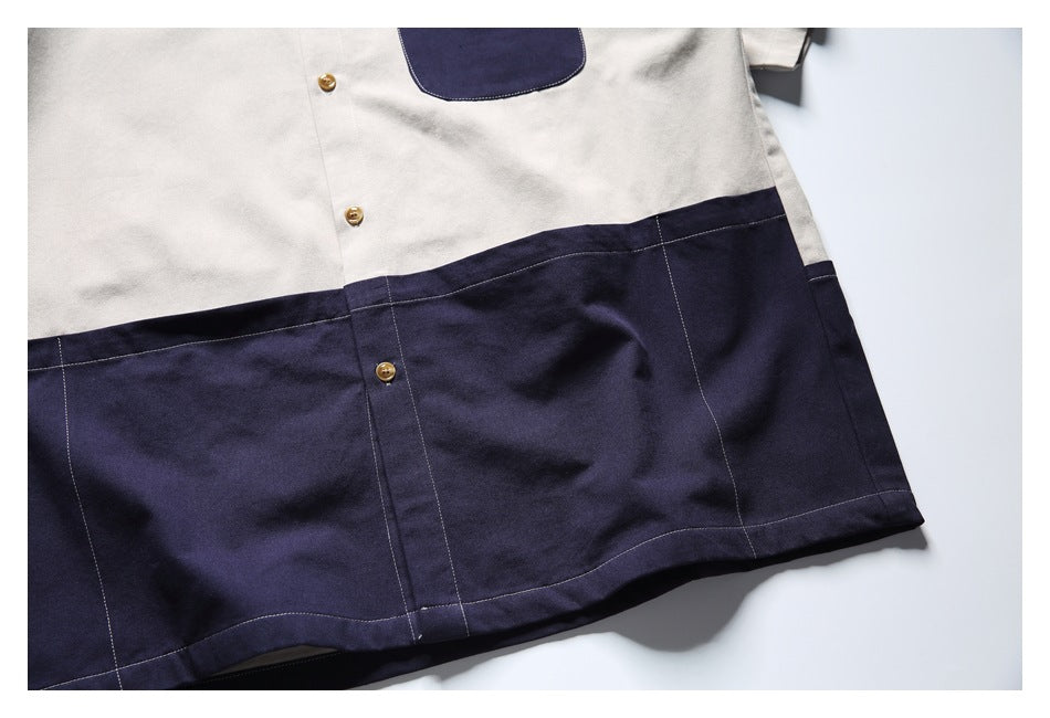 Close-up of the shirt's light beige and navy color-blocked lower section with tan buttons and stitched panels.