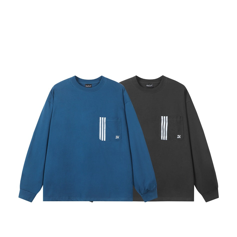 Blue and charcoal long-sleeve crew-neck shirts shown from the front, each with a striped chest pocket.