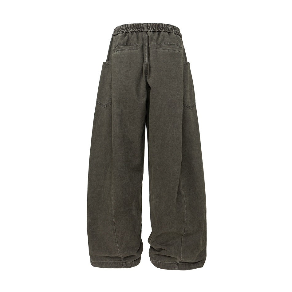 Back view of loose, wide-leg charcoal gray trousers with an elastic waist, two rear pockets, and side pockets.