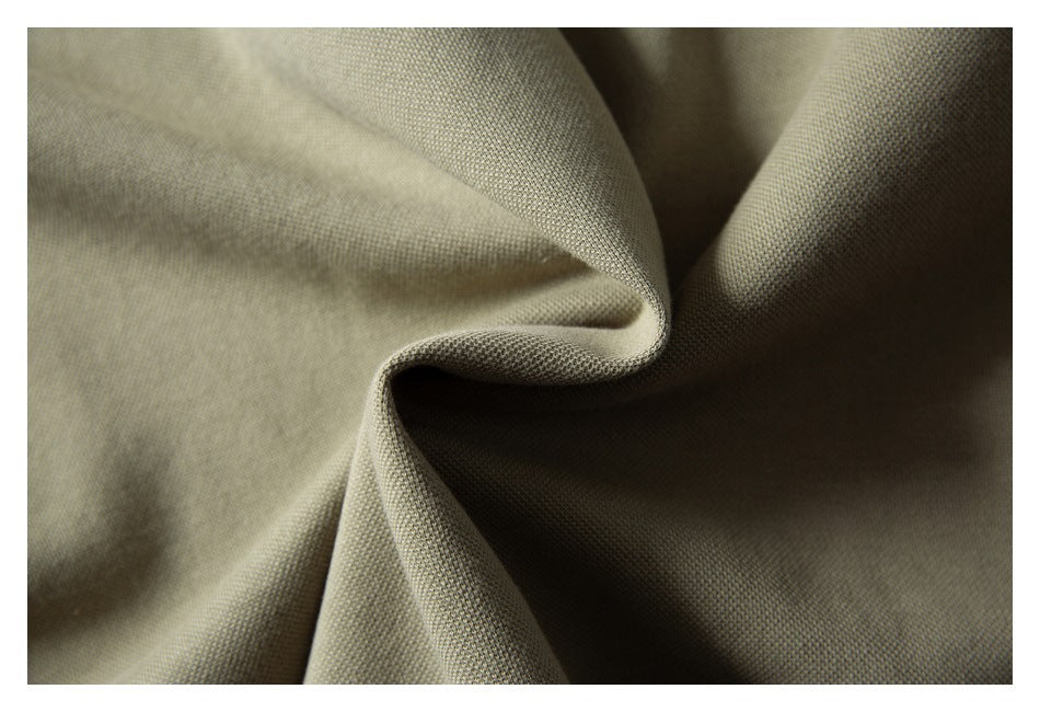 Macro view of olive-khaki fabric draped into soft folds.