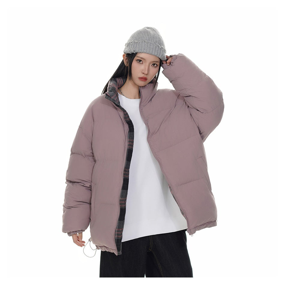Model wearing a mauve puffer jacket with plaid inner trim, a gray knit beanie, white top and dark pants.