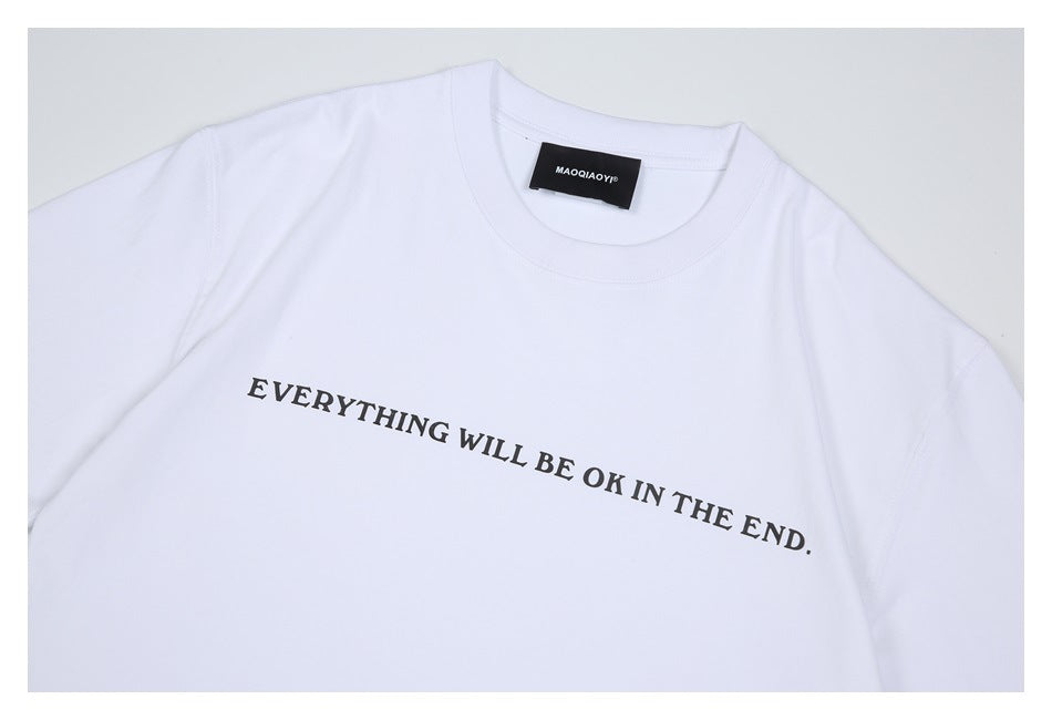 Close view of a white crew-neck T-shirt with black “EVERYTHING WILL BE OK IN THE END.” chest text.