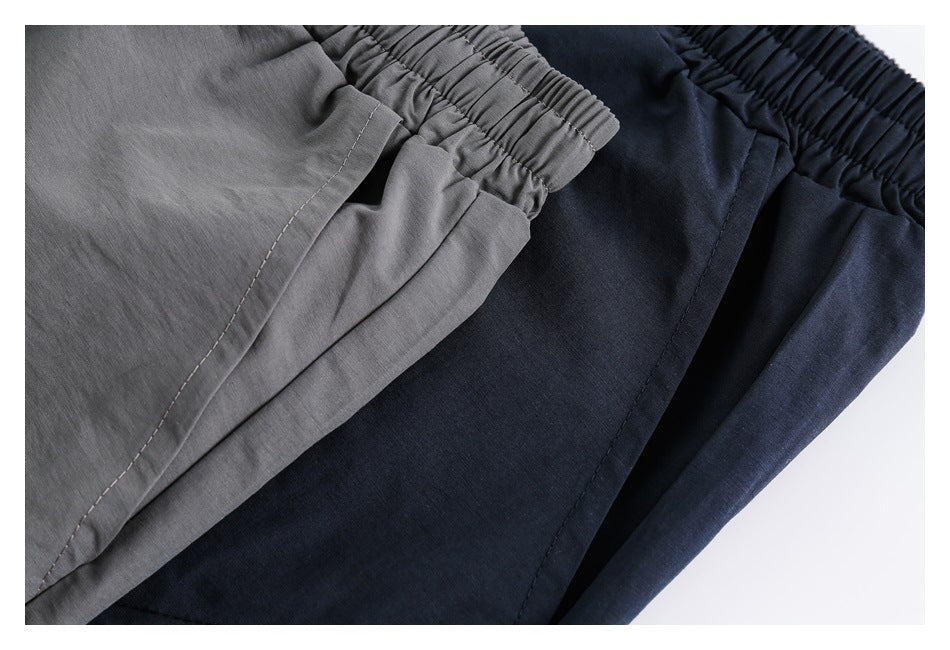 Gray and navy bottoms overlapped, showing elastic waistbands and side seams.