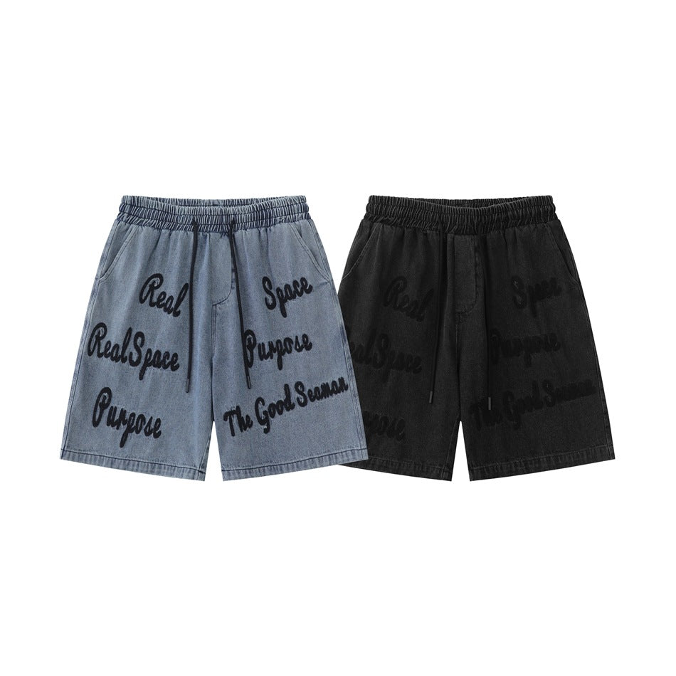 Front views of blue and black denim shorts with elastic waistbands, drawstrings, pockets, and script lettering.