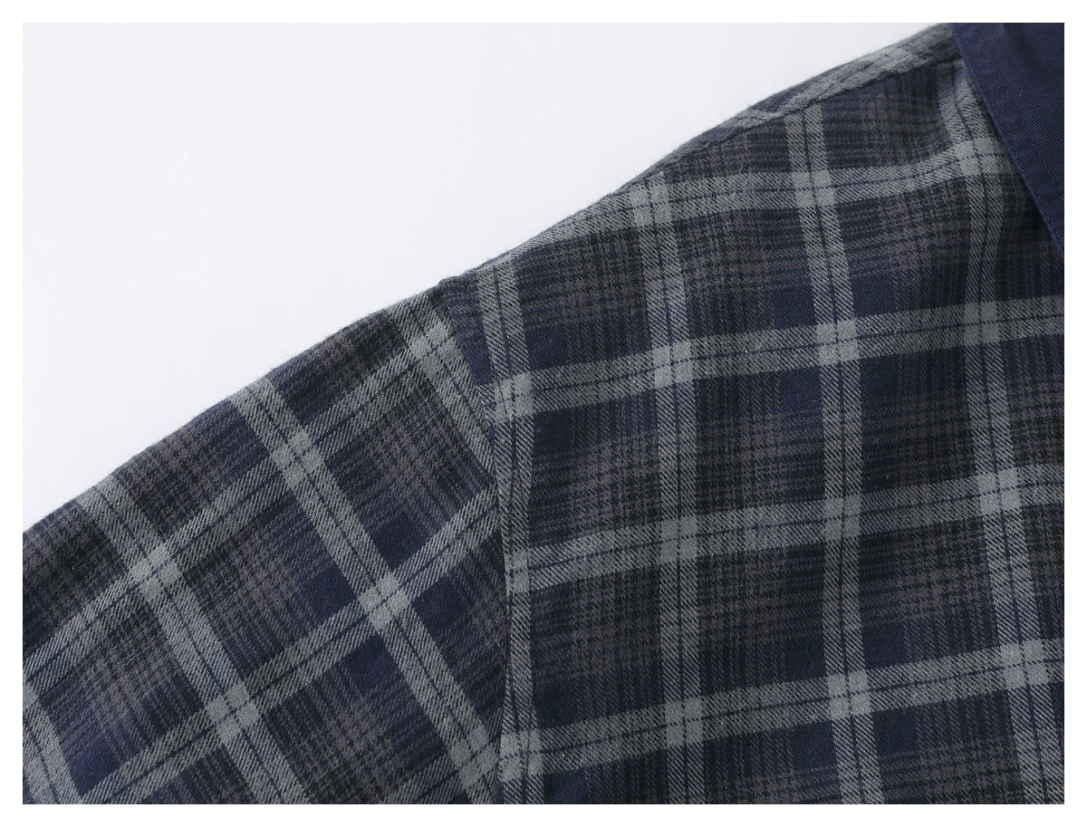 Close-up of a shoulder seam and dark blue and gray plaid fabric on the jacket.