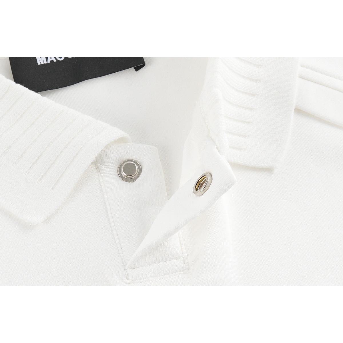Close-up of a white polo shirt's ribbed collar and silver snap fastener.