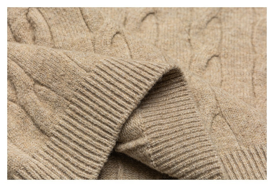 Close-up of a beige sweater's ribbed cuff against a cable-knit body.