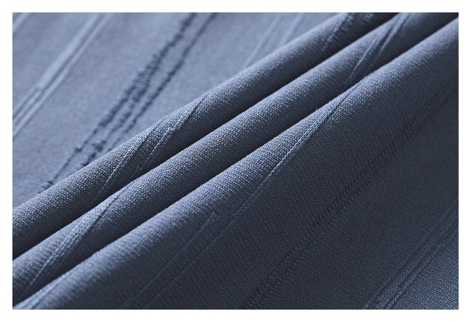 Macro view of the blue-gray top's textured fabric and raised vertical stripes.