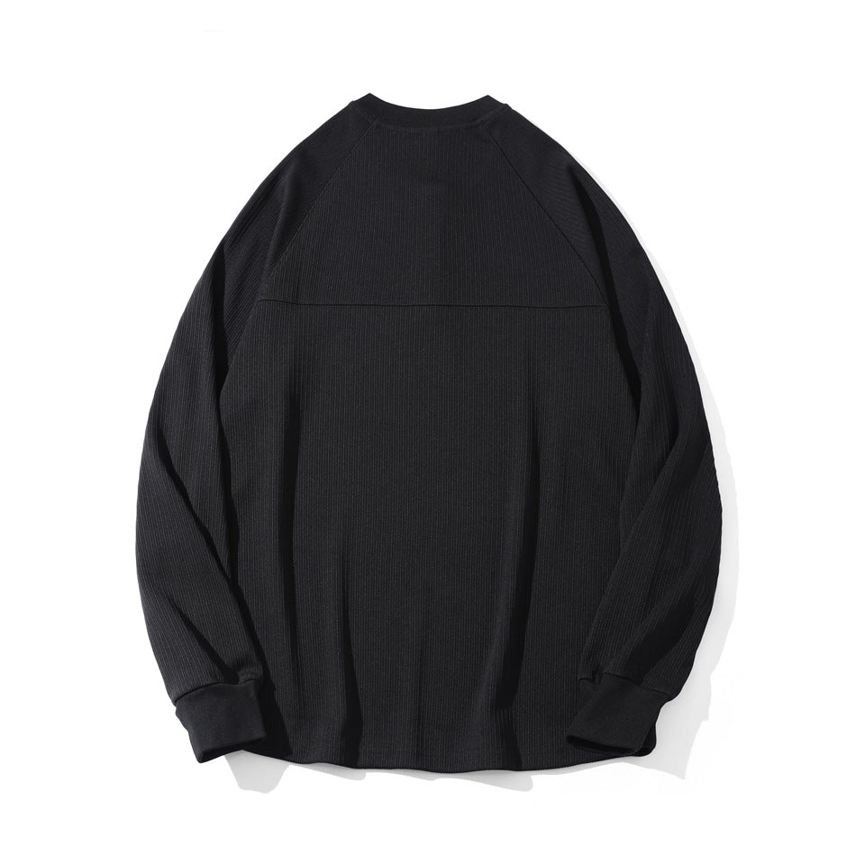 Back view of a black ribbed long-sleeve top with raglan seams and ribbed cuffs, laid flat.
