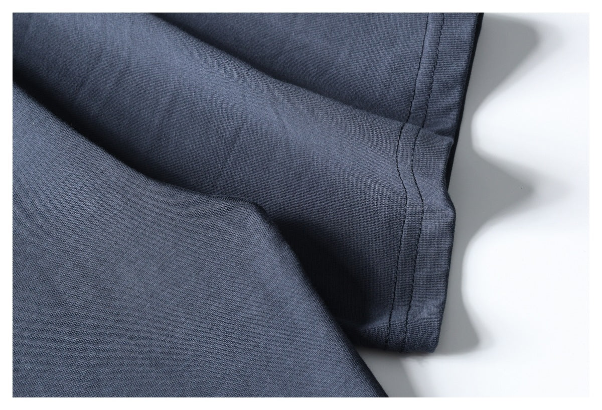 Close-up of a slate-blue garment edge with a double-stitched seam.