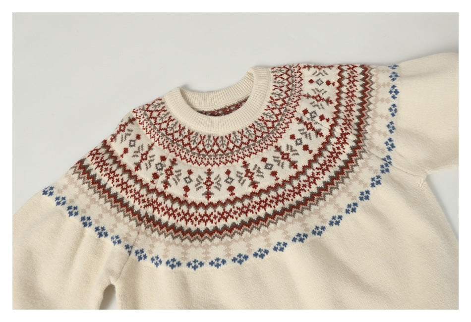 Front of an ivory crew-neck sweater laid flat, showing a red, taupe, and blue geometric yoke pattern.
