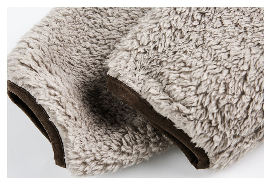 Close-up of plush gray garment fabric with dark brown edging around an opening.