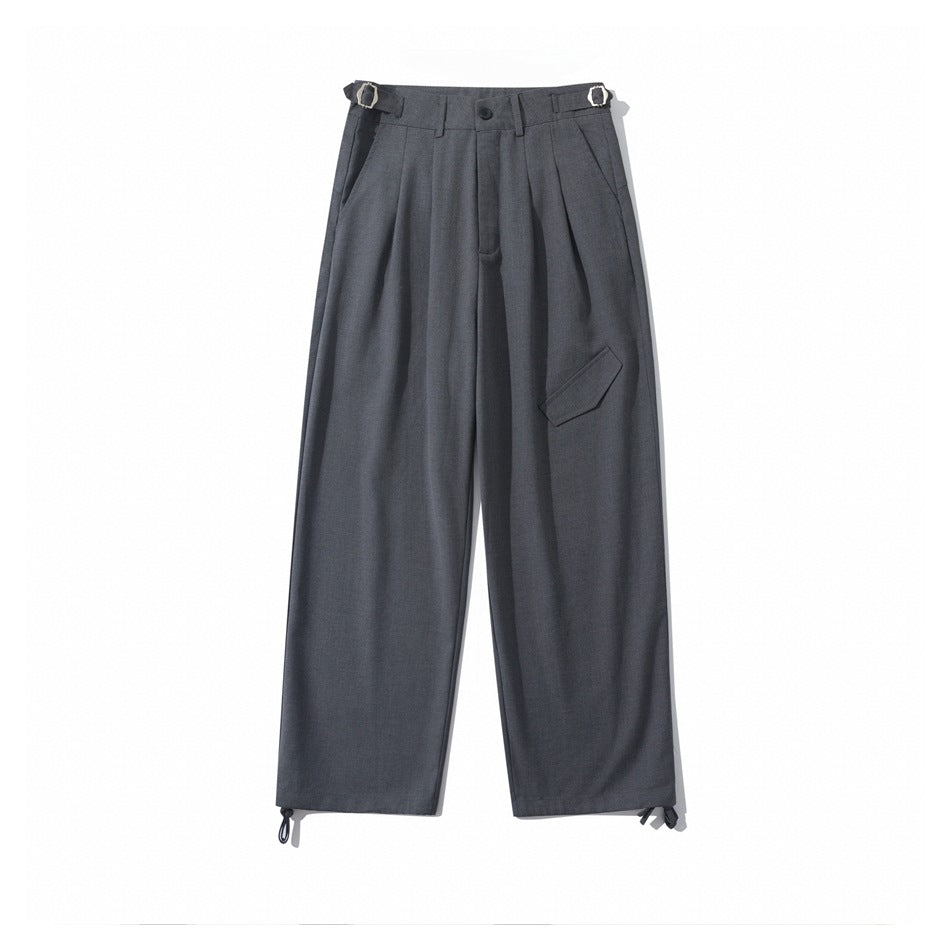Gray wide-leg pleated trousers flat lay with side buckle tabs, front flap detail and hem drawcords