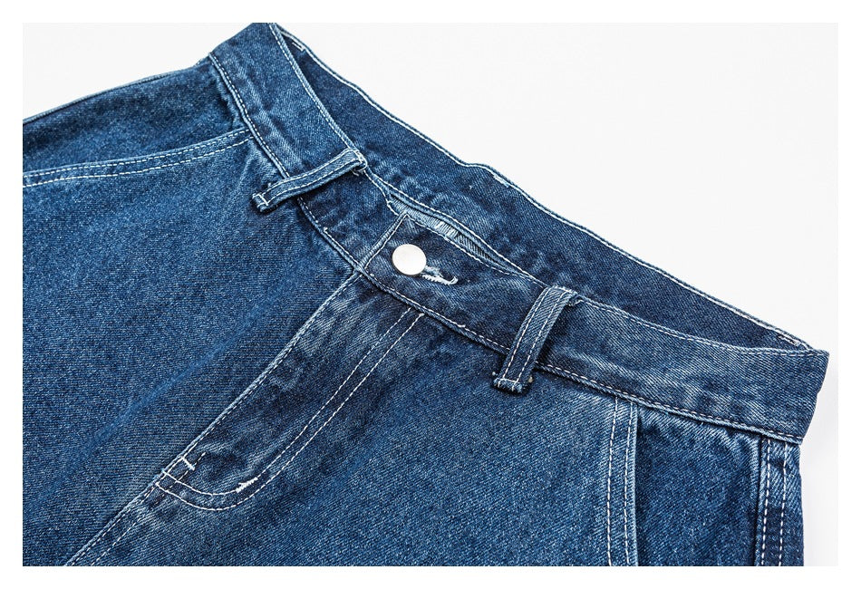 Close-up of blue denim shorts showing the waistband, button closure, belt loops, and curved front pocket.