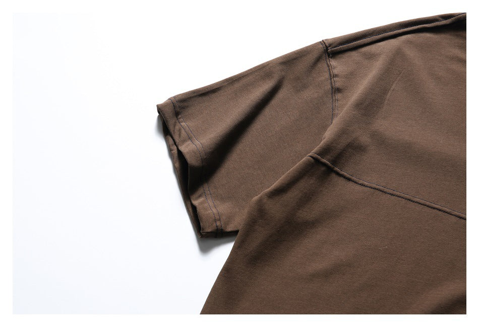 Close-up of the brown T-shirt's short sleeve and curved chest seam against a white background.
