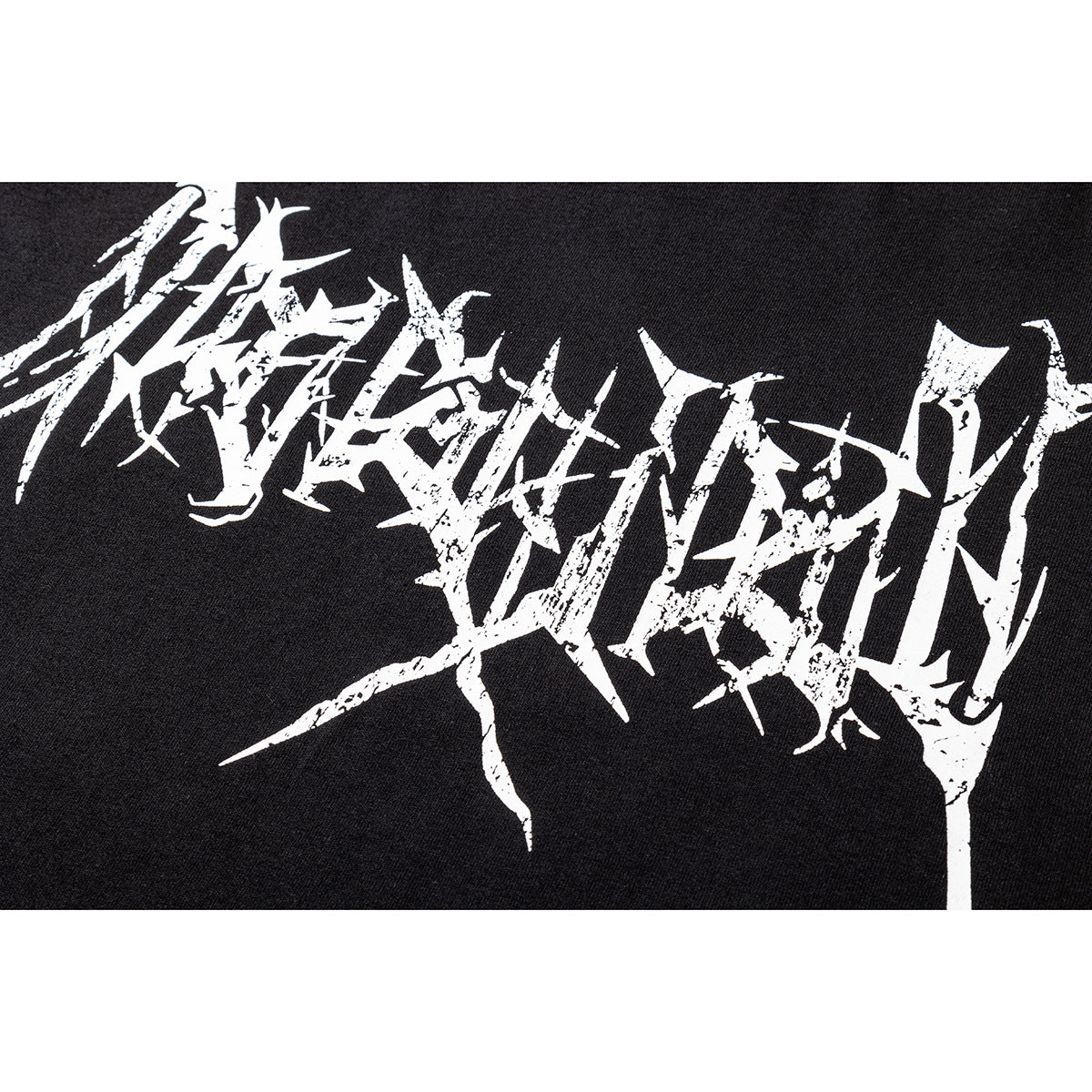 Close-up of a black shirt with a large, distressed white abstract lettering graphic.