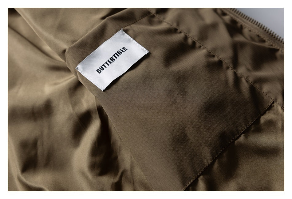 Close-up of a white sewn-in BUTTERTIGER label on the brown jacket.