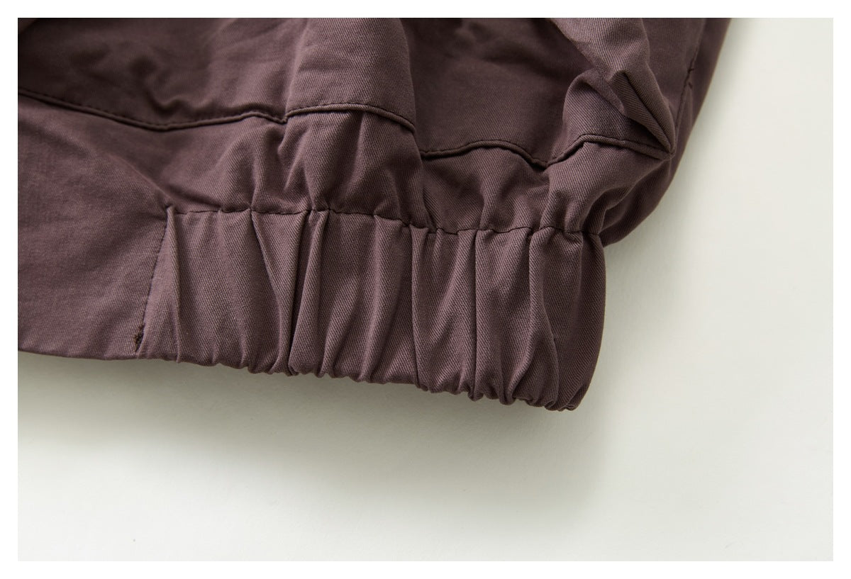 Close-up of the jacket's mauve-brown gathered elastic hem and stitched panel seam.