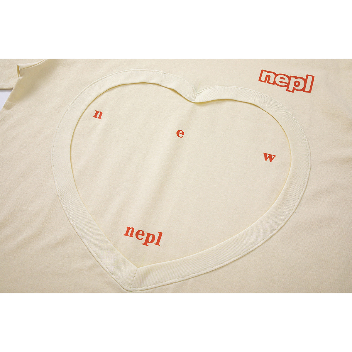 Close-up of a cream T-shirt showing a large heart-shaped neckline detail and red lettering.