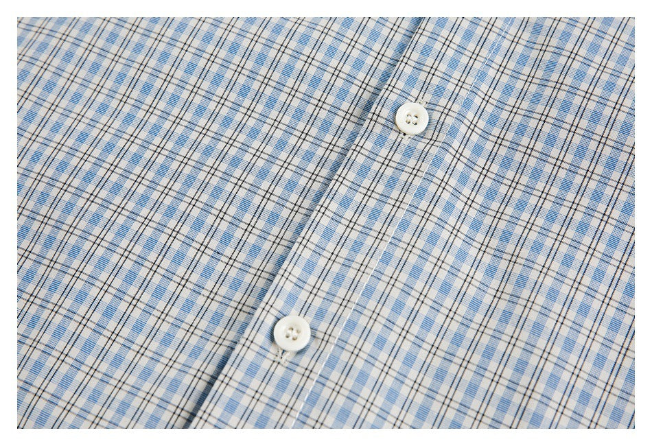 Close-up of a white-button placket on a light blue, white, and black plaid shirt.