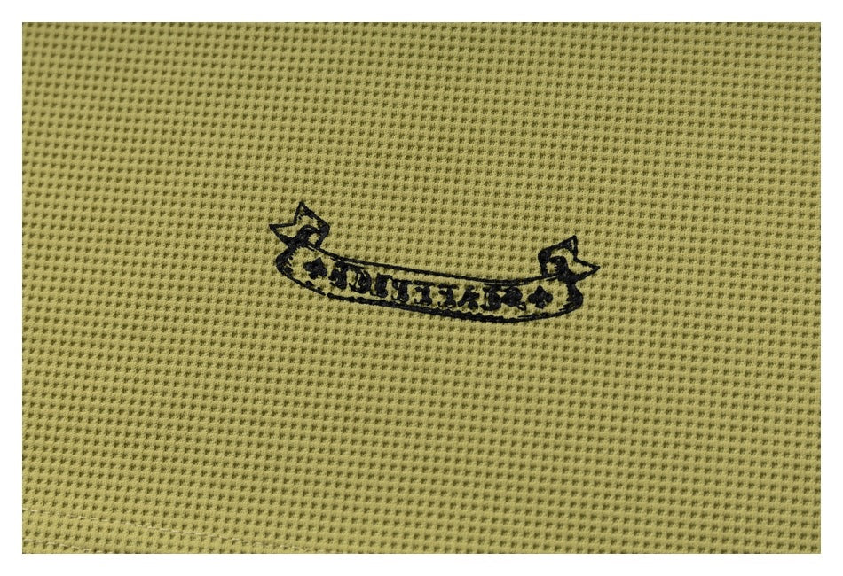 Close-up of a black banner-shaped graphic printed on olive-yellow perforated knit fabric.