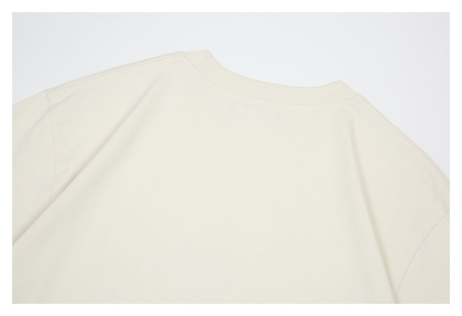 Close-up of an ivory garment's ribbed crew neckline and shoulder seams.