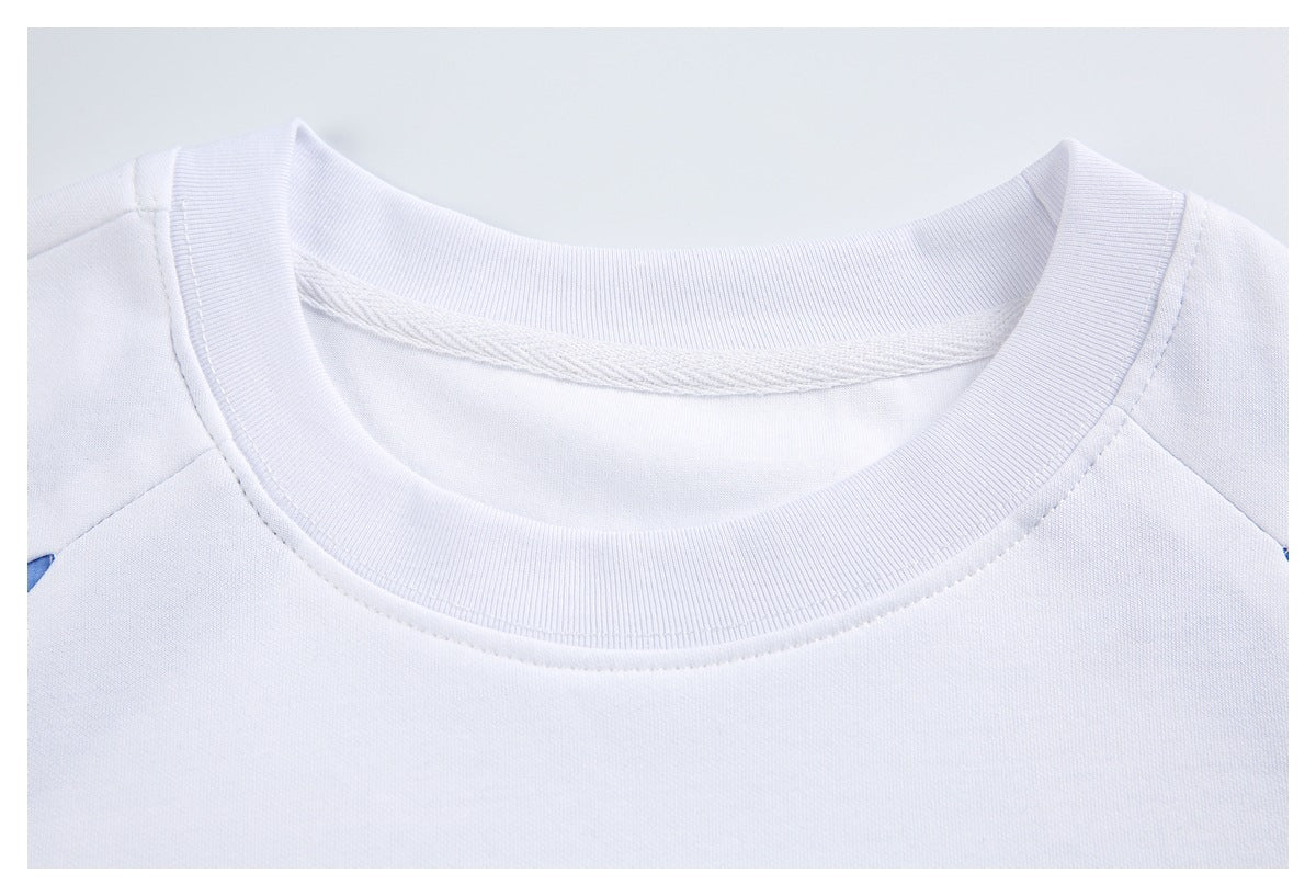 Close-up of a white top's ribbed crew neckline and shoulder seams.