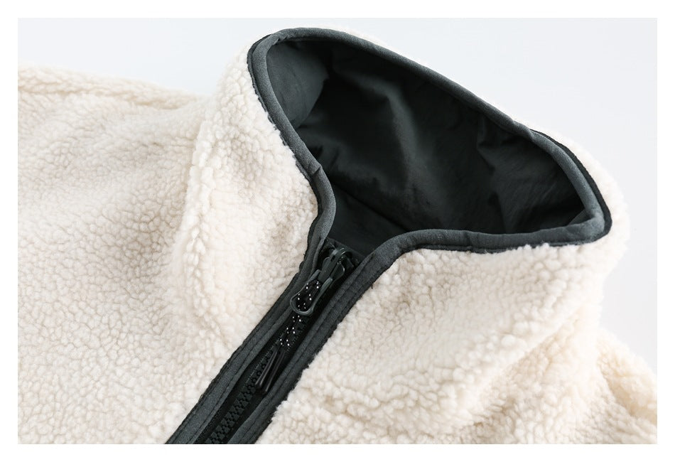 Close-up of the ivory sherpa jacket's black-lined stand collar and front zipper.