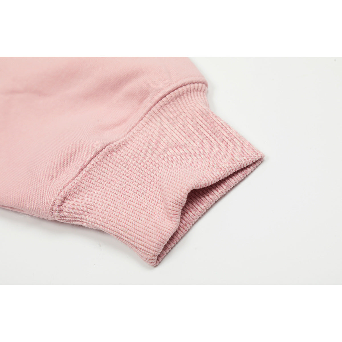 Close-up of the pink sweatshirt's ribbed sleeve cuff and seam.