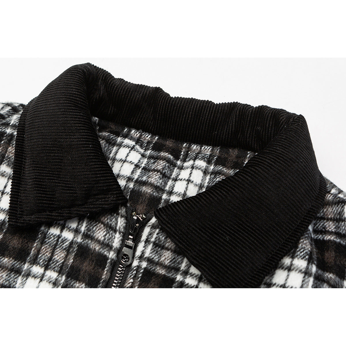 Close-up of a black ribbed collar, metal zipper, and black-and-white plaid jacket fabric.