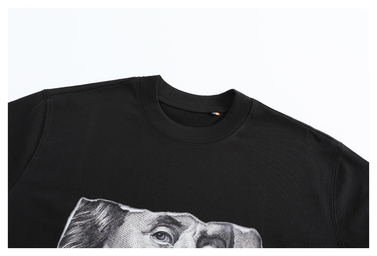 Close-up of a black crew-neck T-shirt with a partial grayscale banknote graphic on the chest.