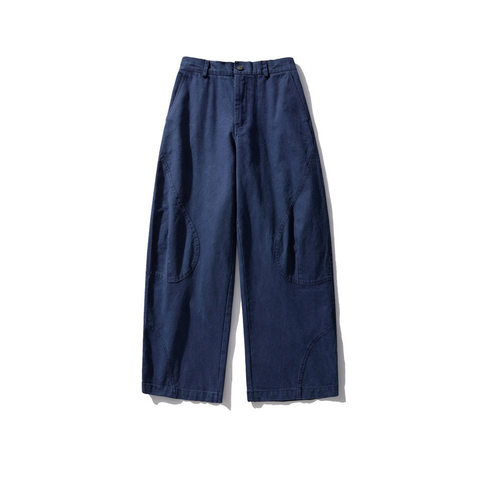 Front view of washed blue wide-leg pants with button closure, belt loops and curved knee seams