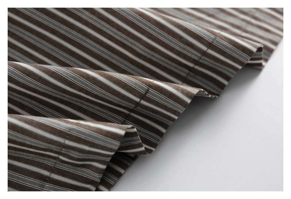 Close-up of the stitched edges and layered hem of a brown, gray, and white striped shirt.