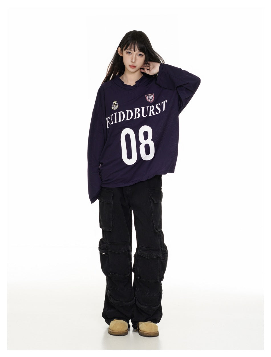 Model in a dark navy hooded jersey with crest graphics and a large white 08, posing with one hand near her neck.