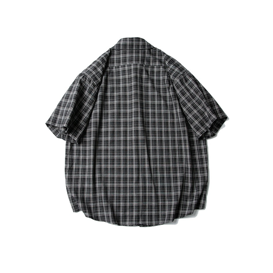 Back view of black and white plaid short-sleeve shirt laid flat