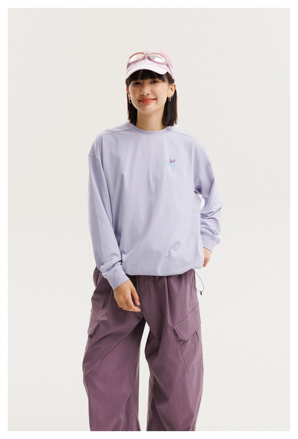Front view of a model wearing a loose lavender long-sleeve shirt and mauve cargo pants.