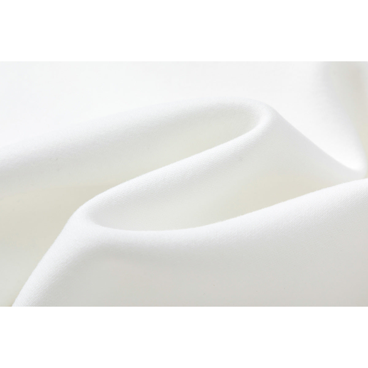 Close-up of smooth white fabric draped in soft folds.