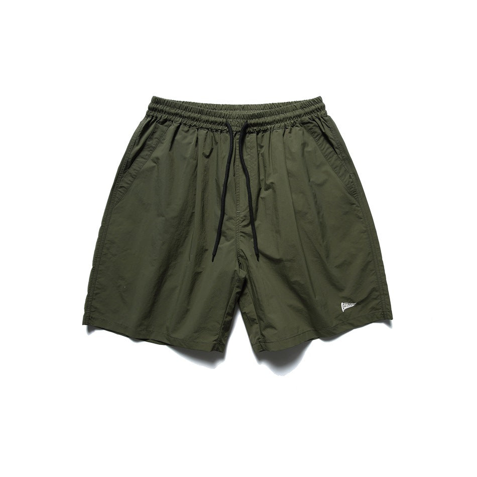 Army green drawstring shorts with elastic waist and side pockets, flat lay front view