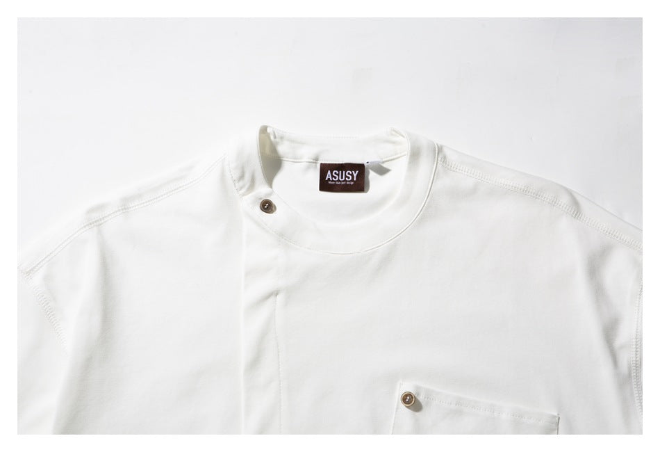 Close-up of a white T-shirt neckline, shoulder seams, brown button, and neck label.