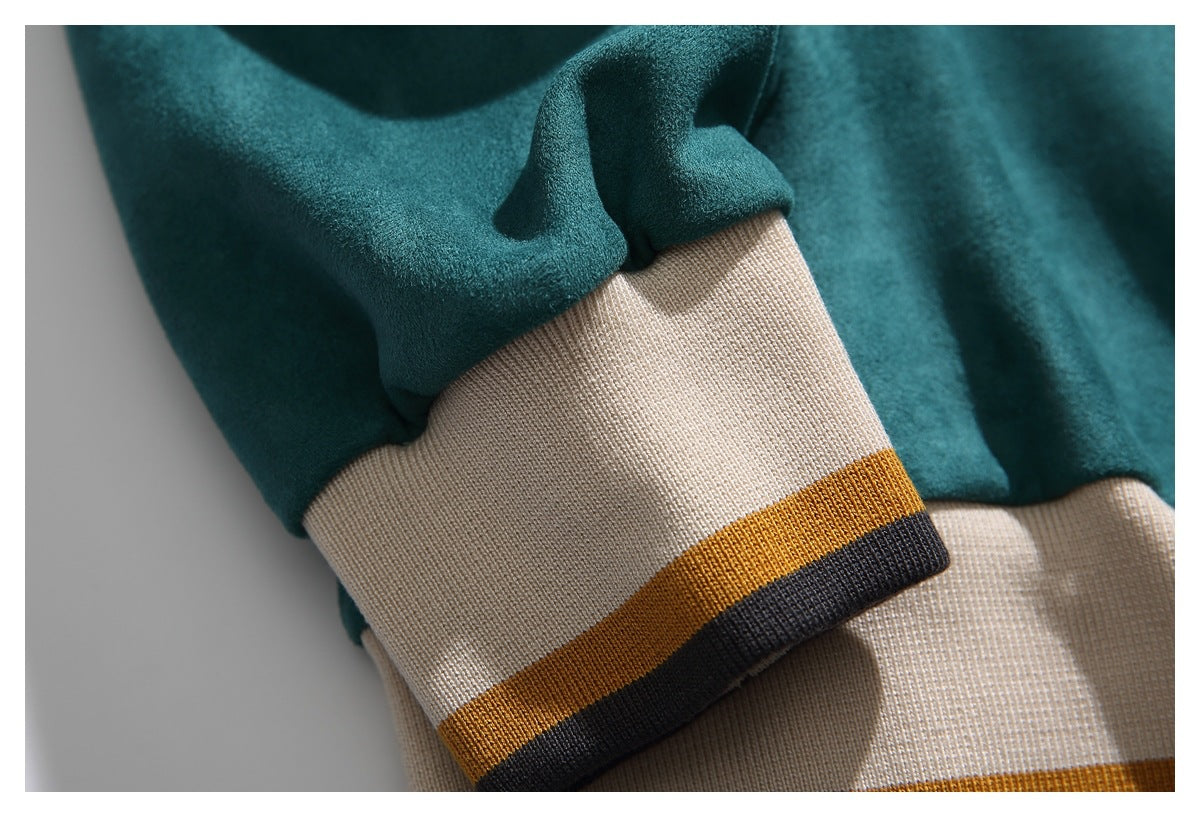 Close-up of a teal sweatshirt sleeve and ribbed cream cuff with mustard and charcoal stripes.