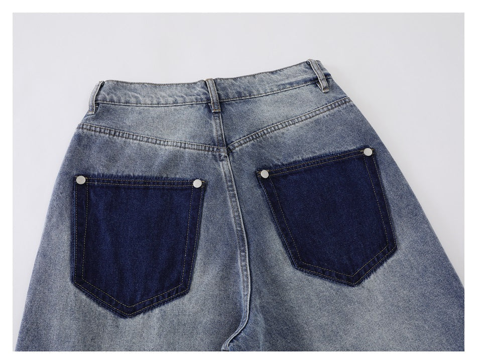 Flat lay of the back waist and upper legs of faded blue jeans with two dark indigo pockets.
