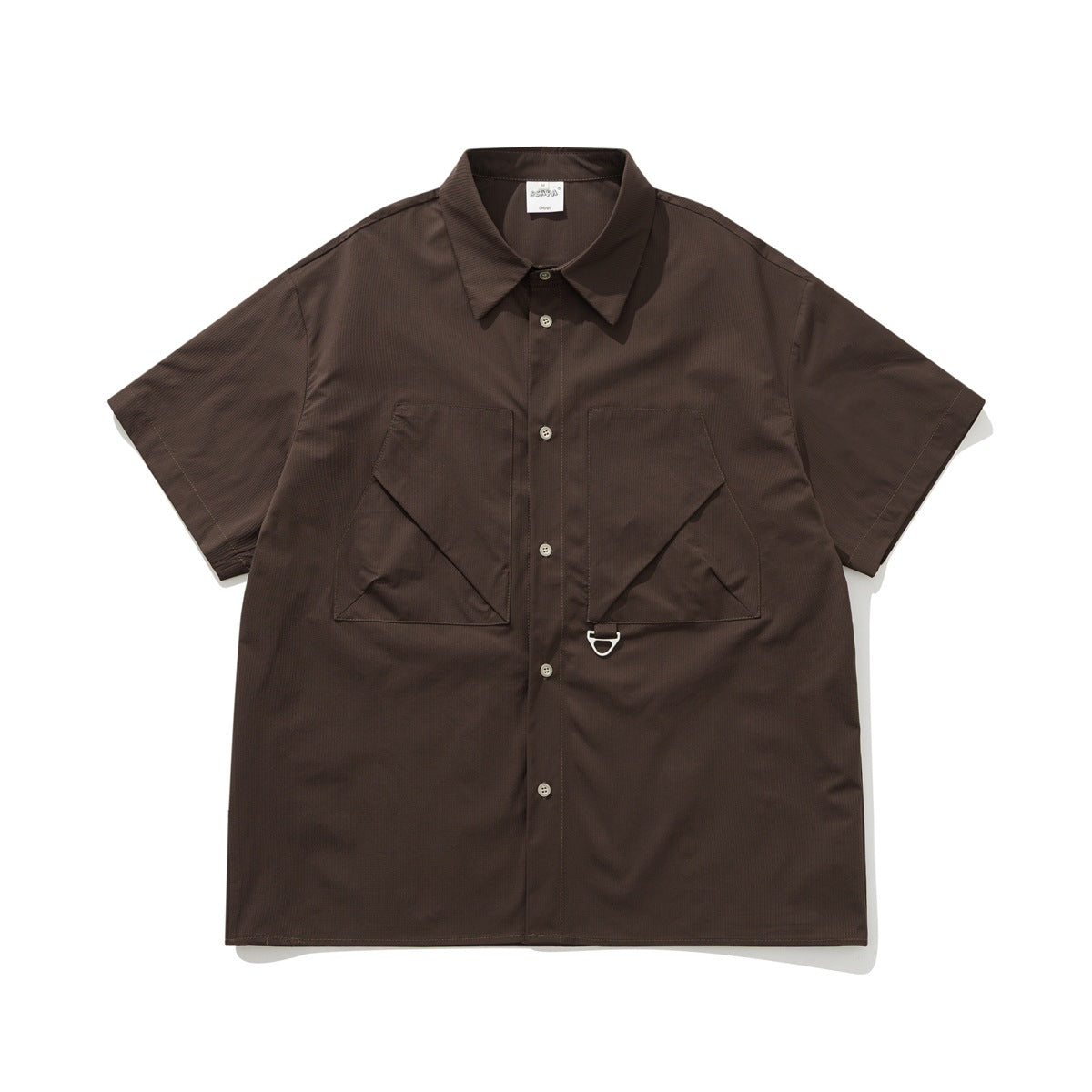 Dark brown short-sleeve button-up shirt with two large angled chest pockets and a metal D-ring, flat lay front view
