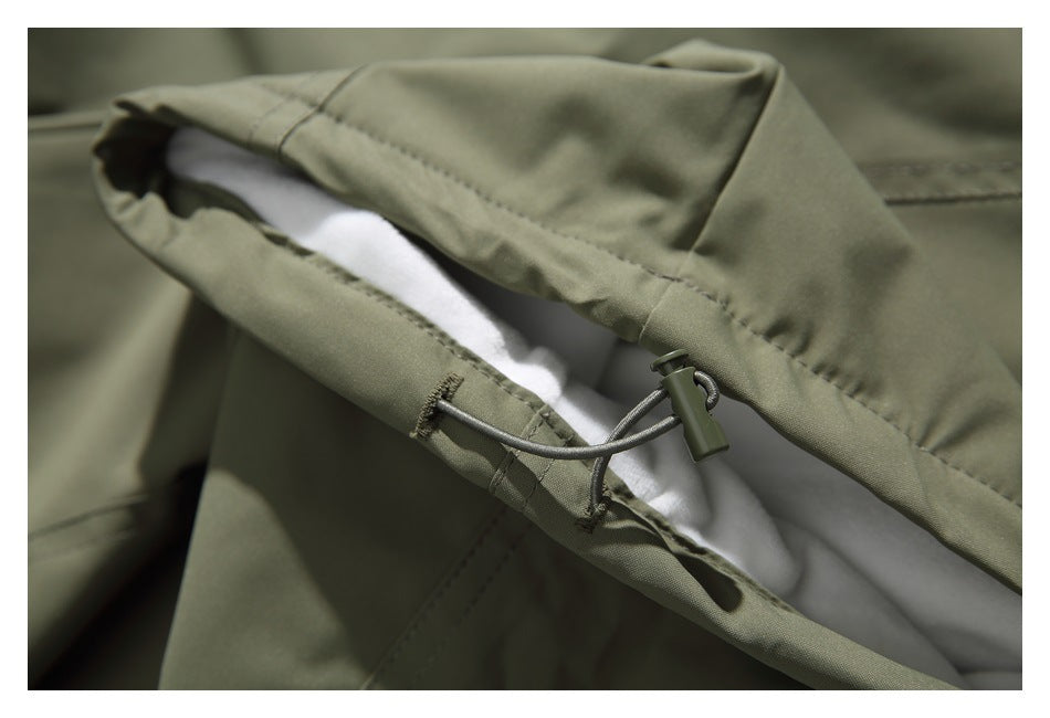 Close-up of an olive-green hem opening with a drawcord toggle and white inner lining.