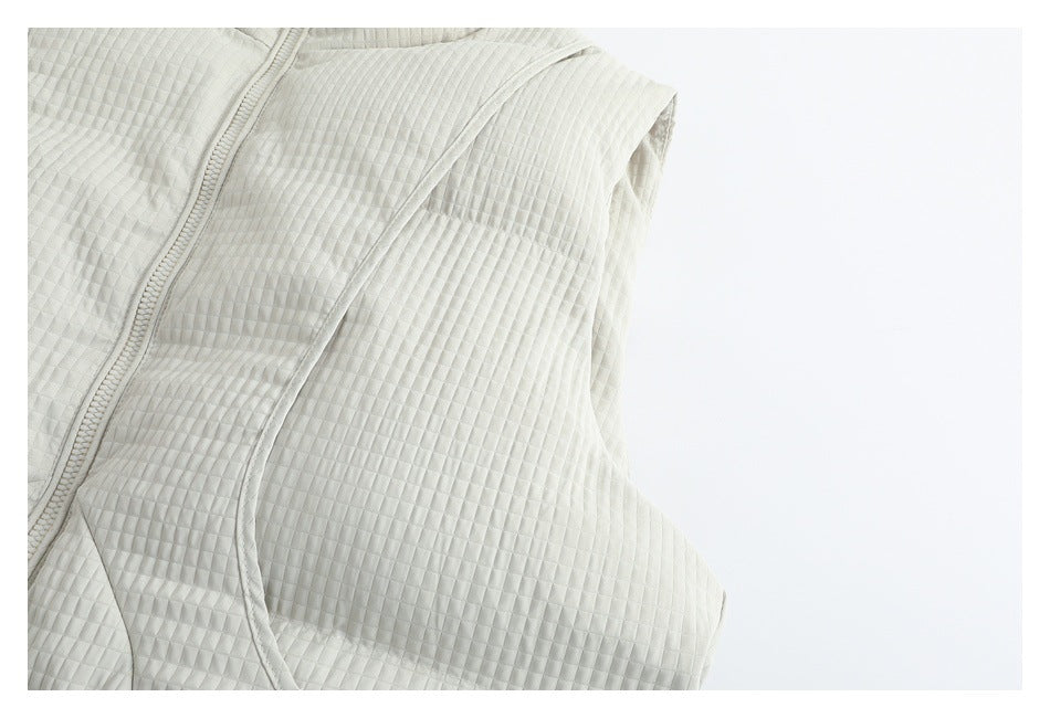 Close-up of the ivory garment's quilted side panel and curved armhole seam.